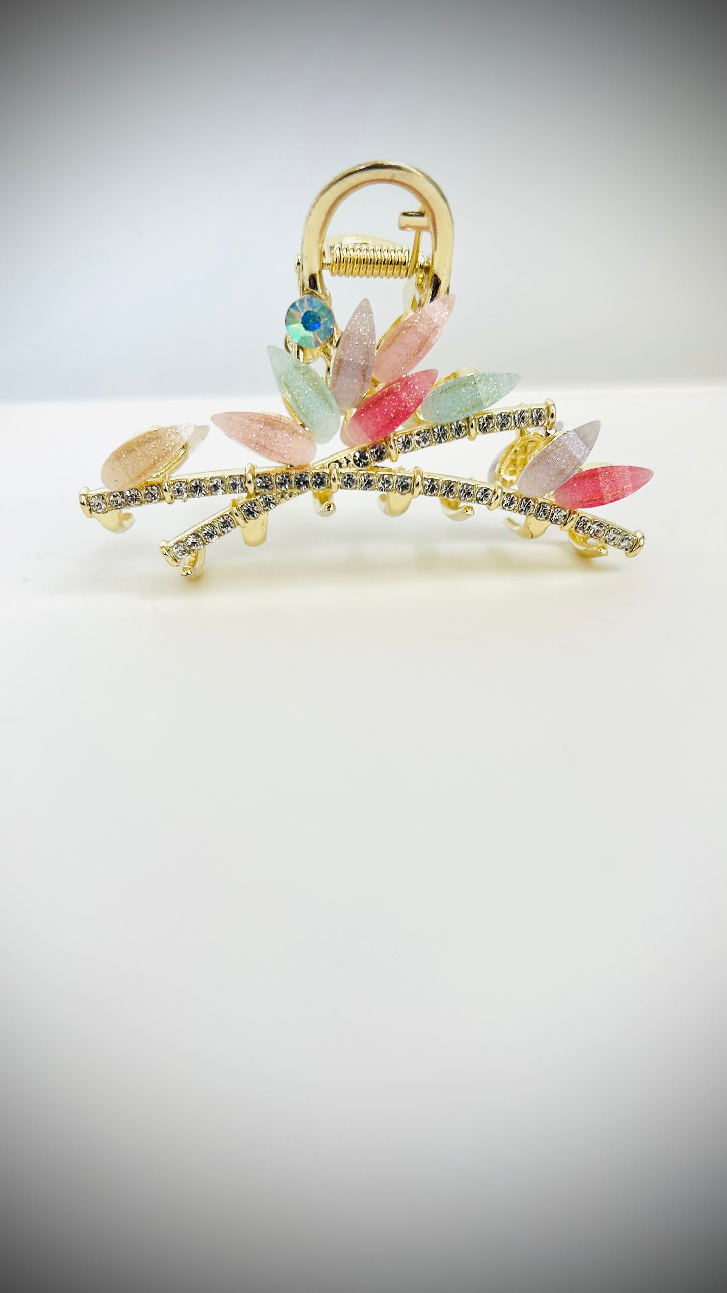 Decorative hairclip with colorful stones on a light gray background