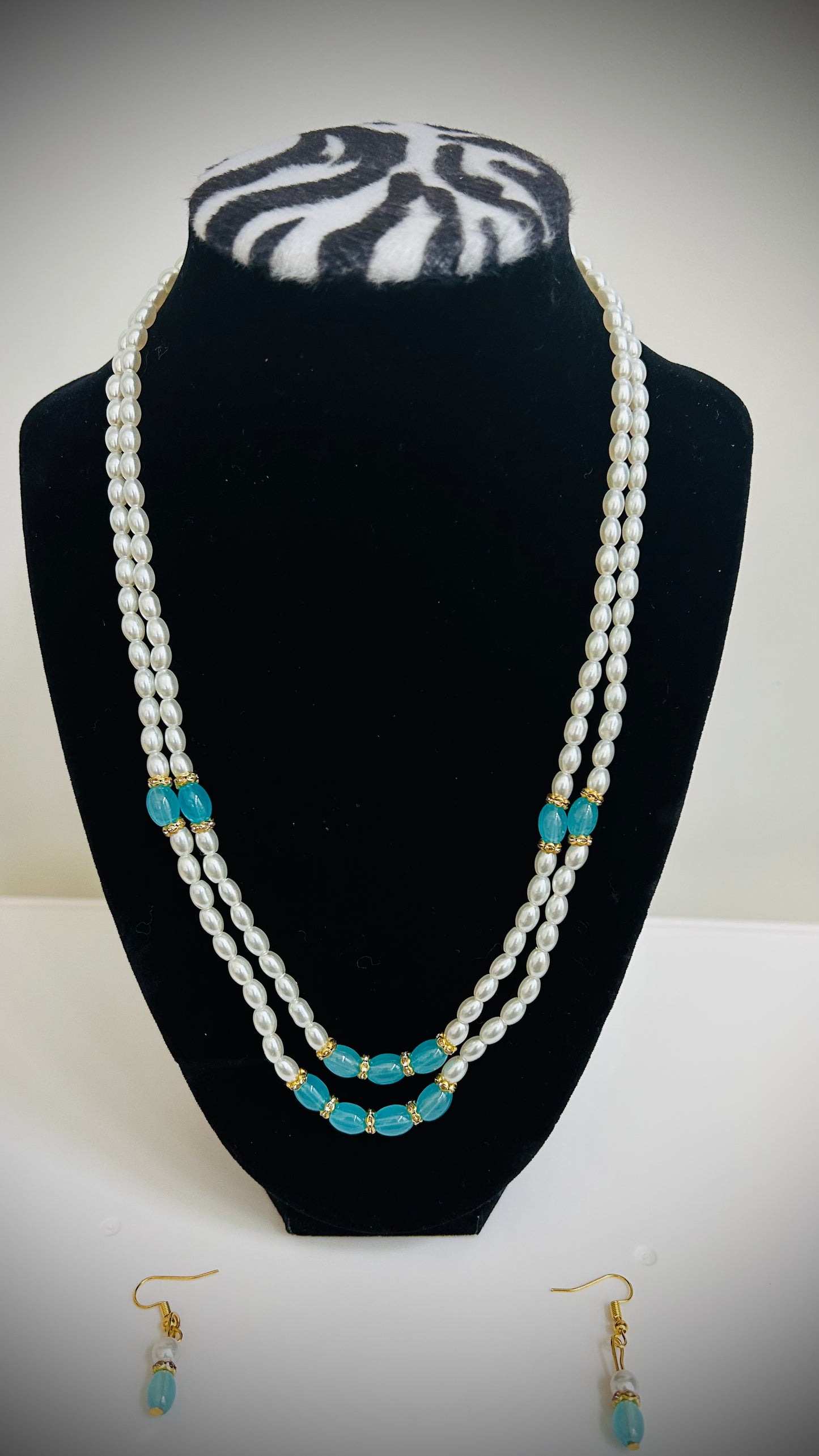 Double-layer white pearl necklace with teal bead accents and matching earrings – festive Desi jewelry set