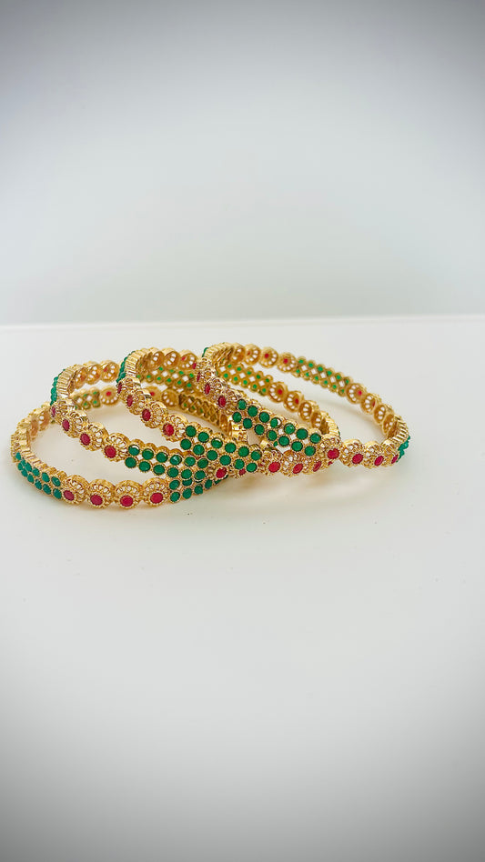 Gold bangles with green and red stones.