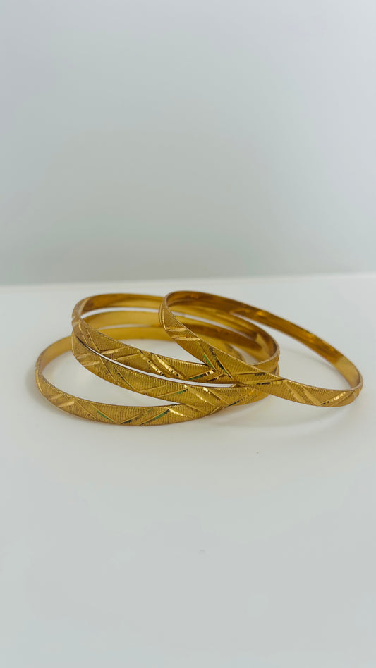 Four gold bangles stacked 