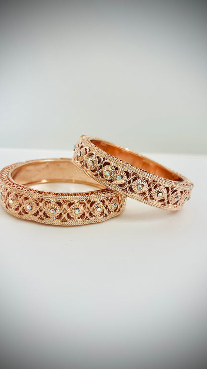 Two rose gold bangles with intricate designs