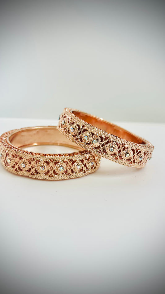 Two rose gold bangles with intricate designs