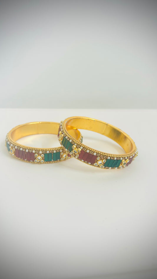Pair of gold bangles with red and green stones