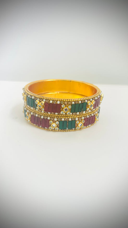 Pair of gold bangles with red and green stones