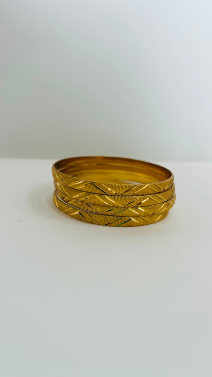 Set of gold bangles on a white background