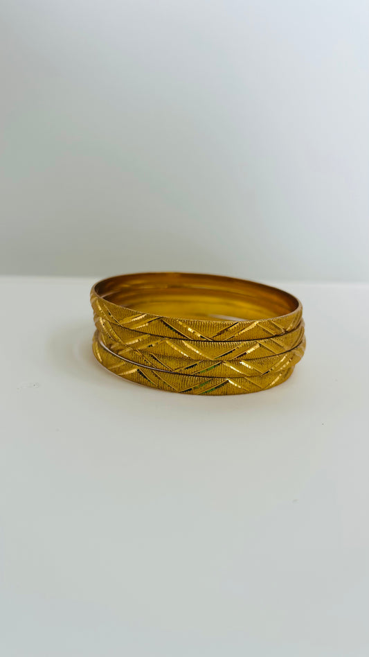 Set of gold bangles on a white background