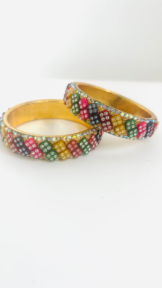 Two colorful beaded kids' bangles on a white background