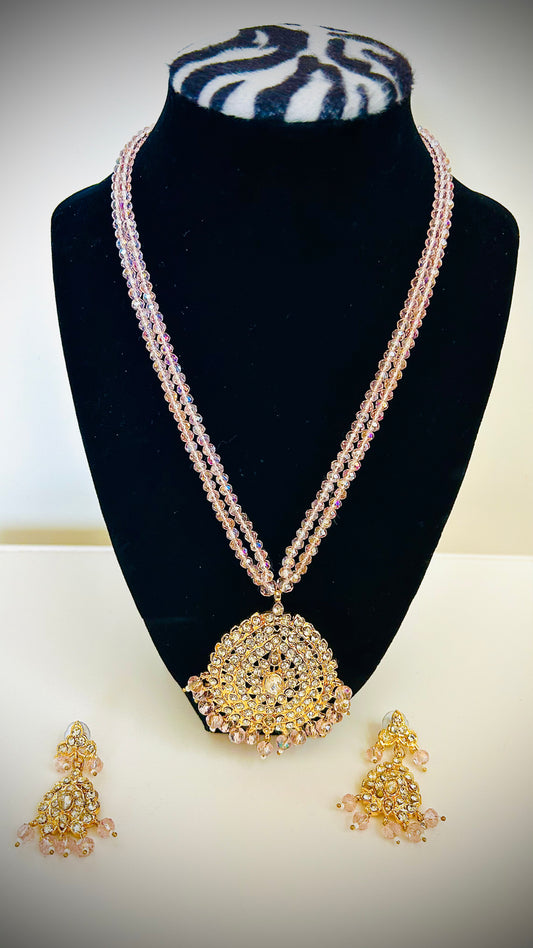 Jewelry set with necklace and earrings on a black stand against a white background