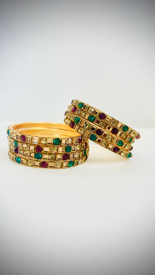 Gold bangles with green and red gemstones 