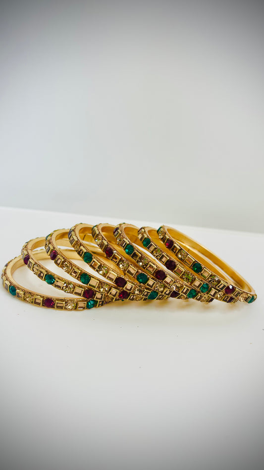Gold bangles with green and red gemstones 