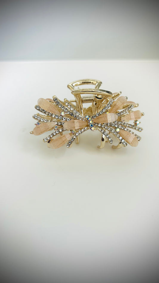 Goldand peach hair clip with decorative elements on a white background
