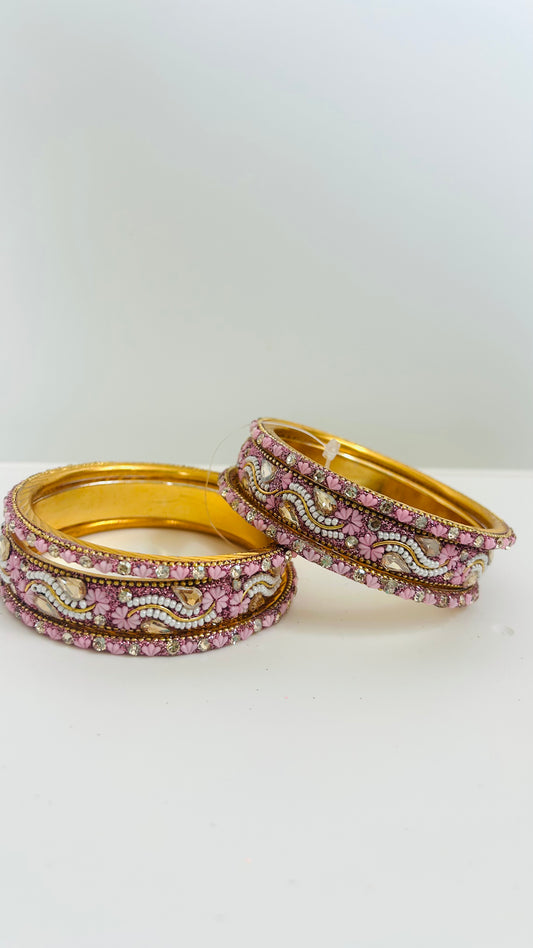 Set of gold bangles with pink and white stones 
