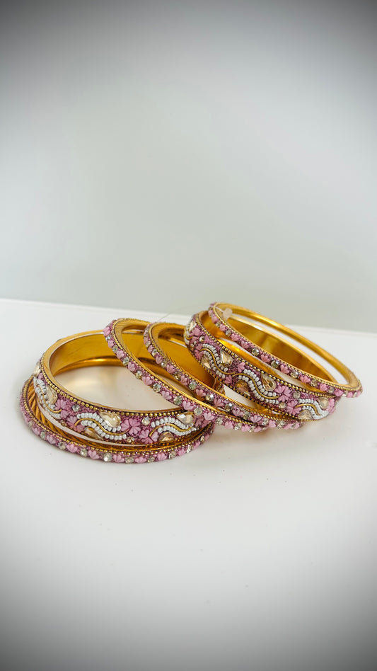 Set of gold bangles with pink and white stones 