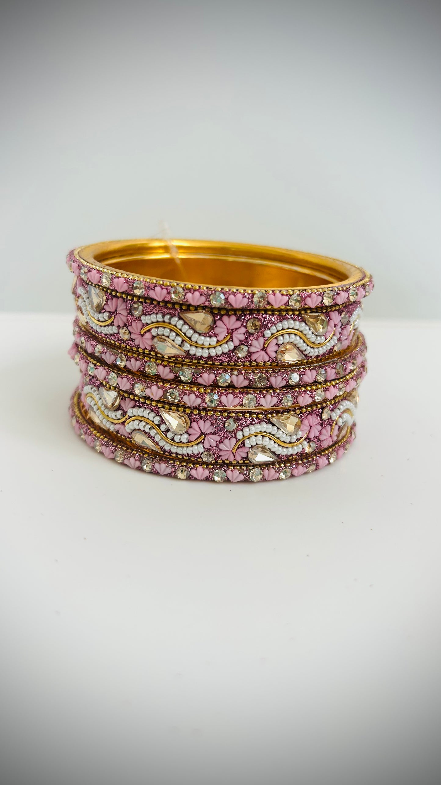 Stack of pink bangles with gold accents 