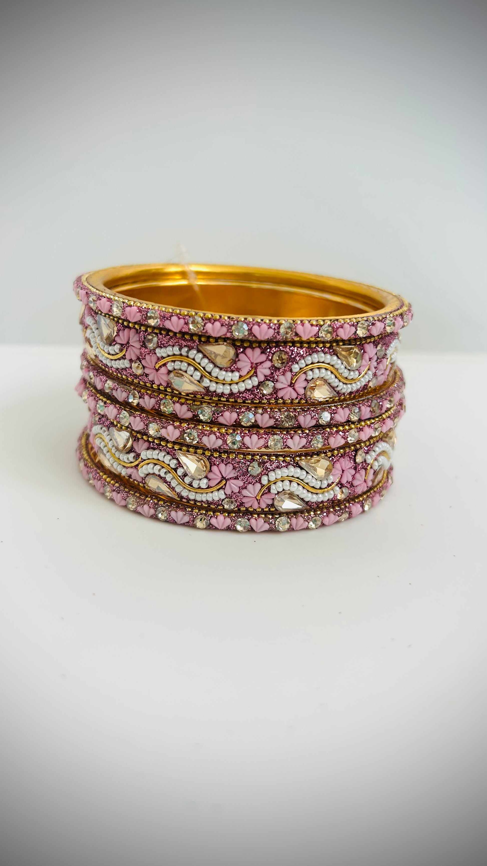 Stack of pink bangles with gold accents 