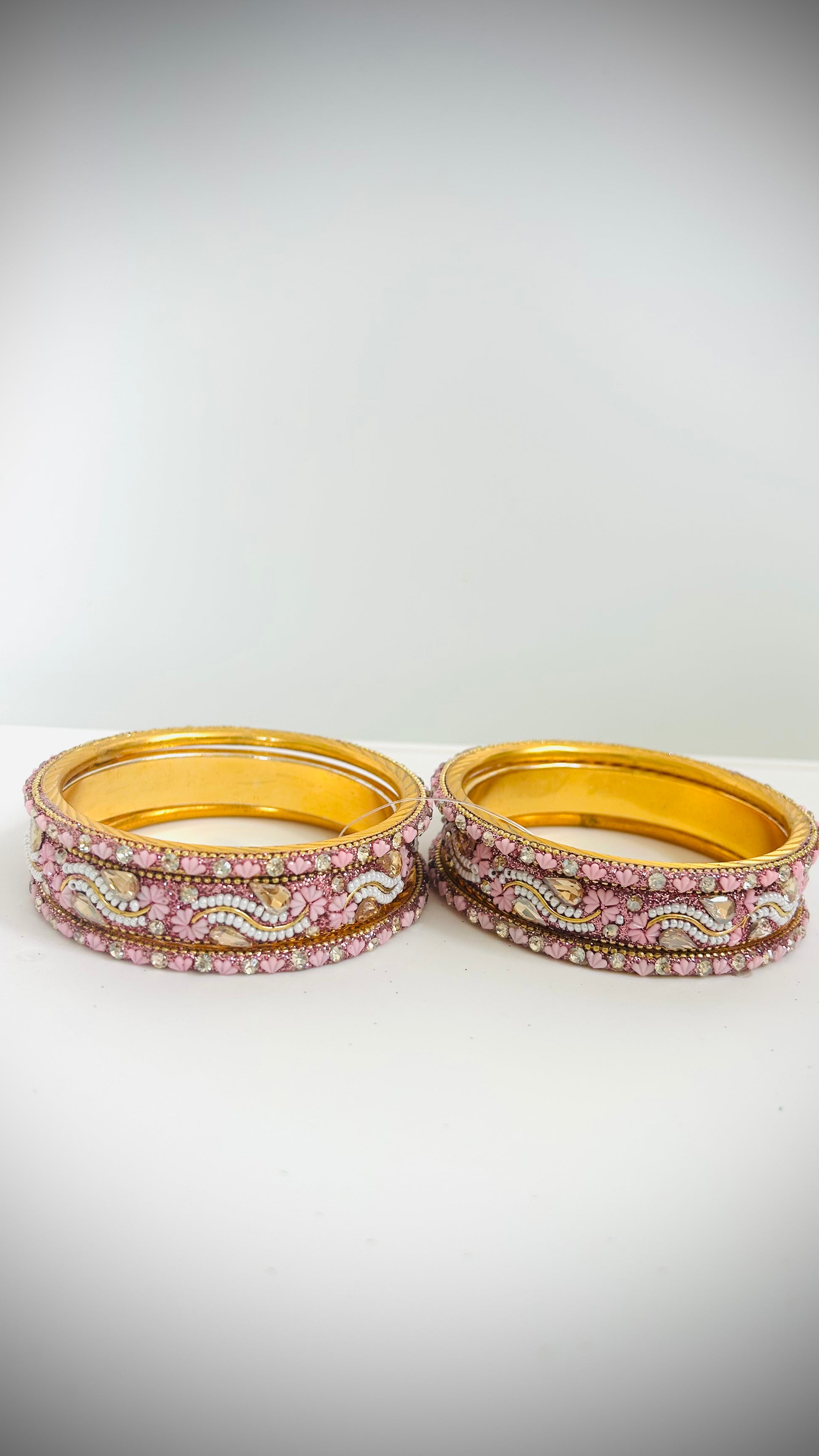 Set of gold bangles with pink and white stones 