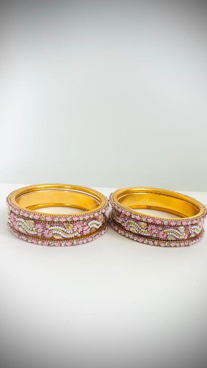 Set of gold bangles with pink and white stones 